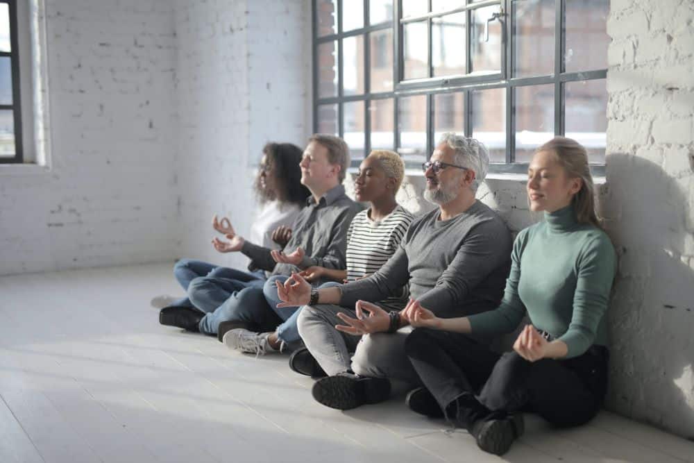 Coworkers meditating together in the office