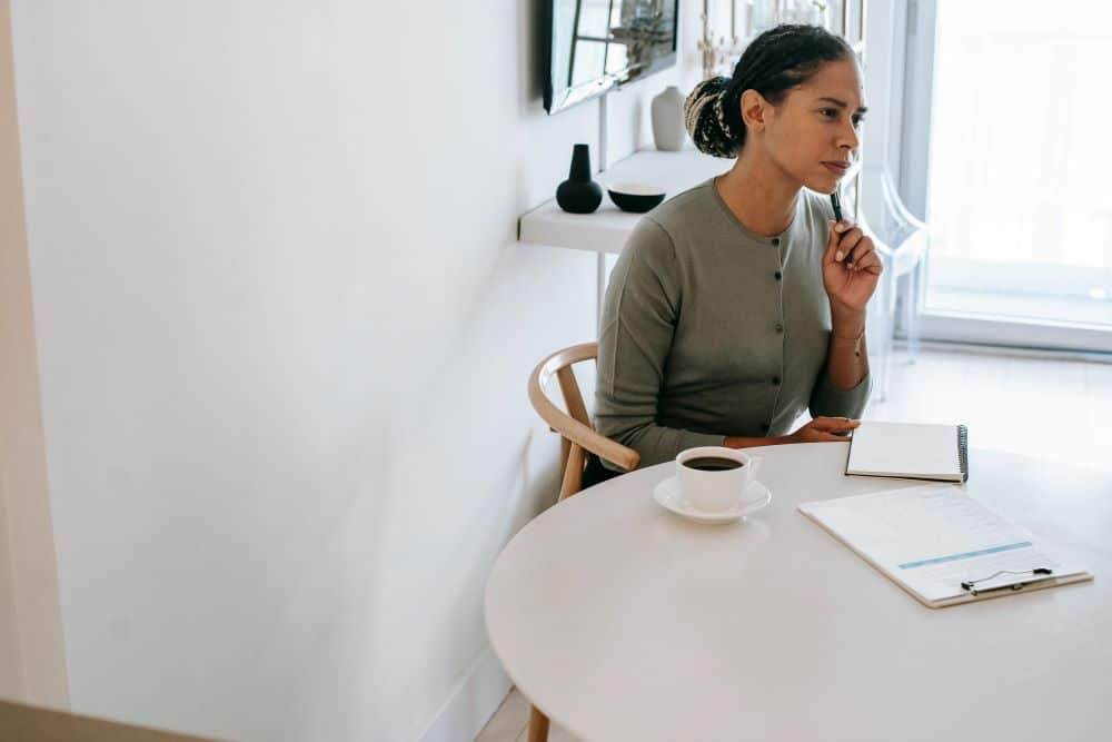 Lady brainstorming the psychology of influence around her, at her desk.